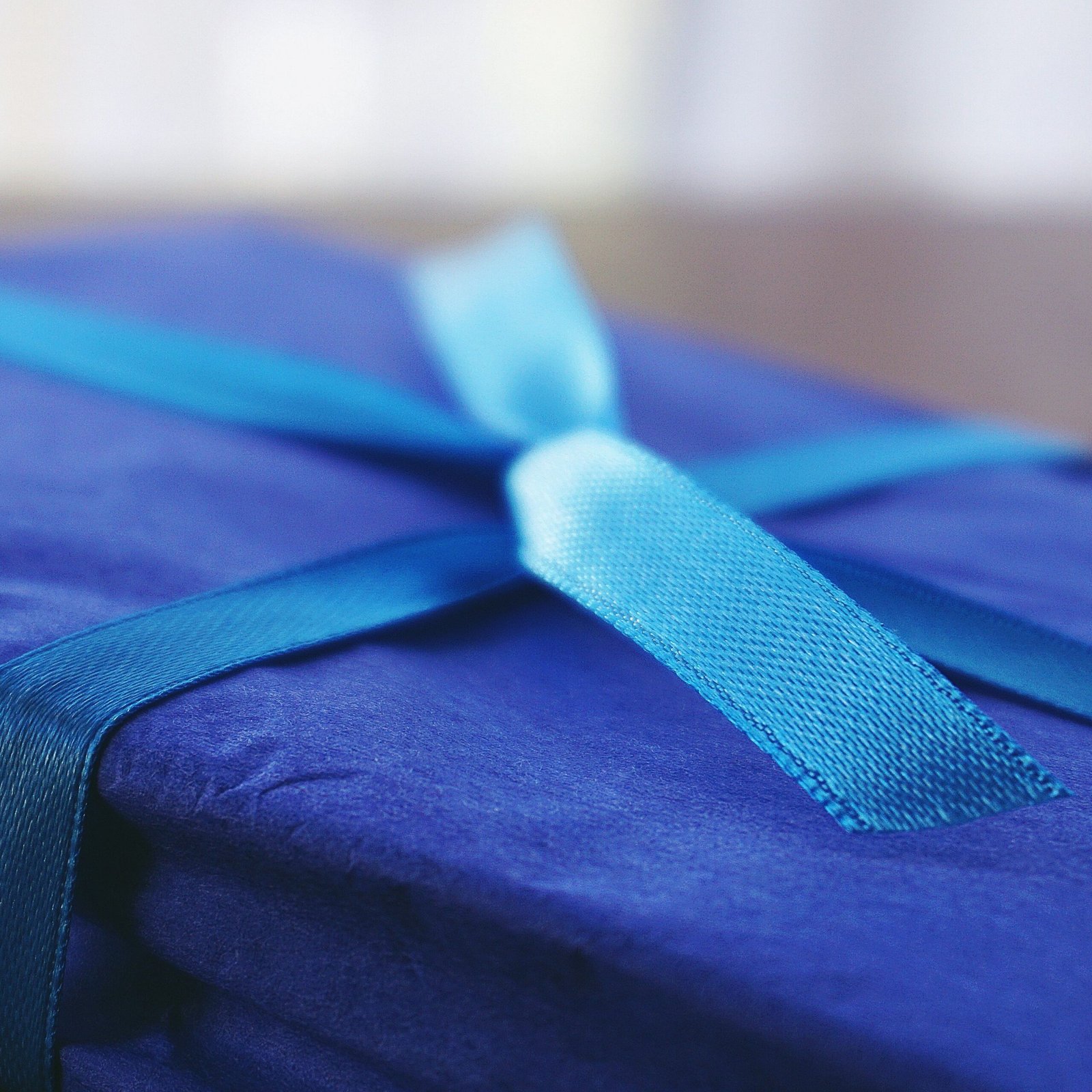 A blue gift box with a satin ribbon, perfect for celebrations and surprises.